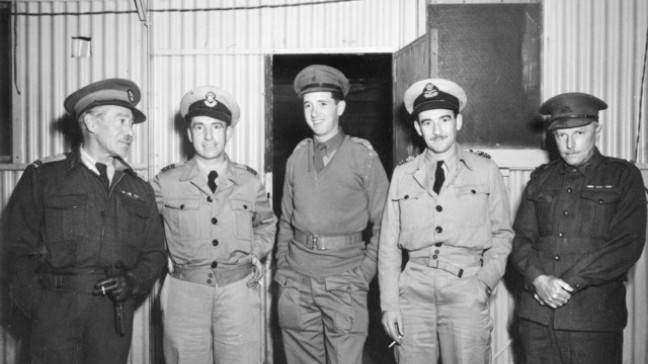 Officers of Central Bureau await air transport to Manila for Colonel Sandford (AWM P00473.010 https://www.awm.gov.au/collection/C39512)’