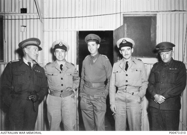 Officers of Central Bureau await air transport to Manila for Colonel Sandford (AWM P00473.010 https://www.awm.gov.au/collection/C39512)’