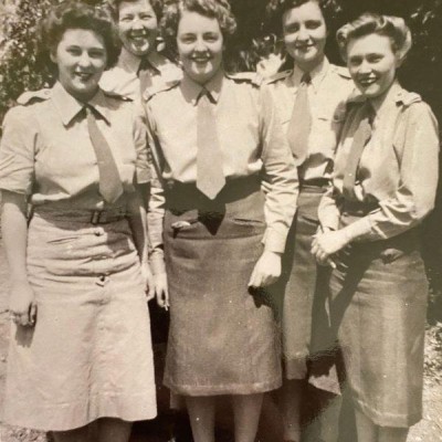 Full-length photograph of five young women in uniform.