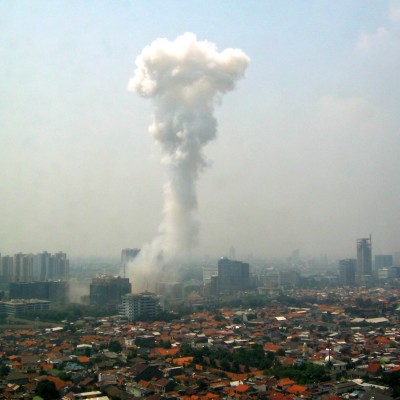 A large plume of smoke shoots into the air from the Jakarta city skyline. 