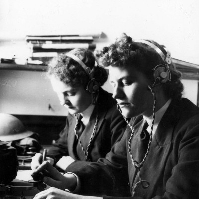 Image of two women using the encoding machine. 