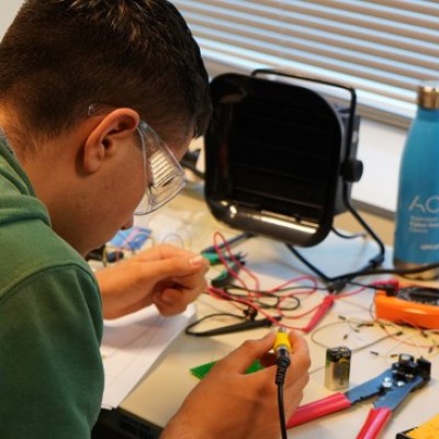 Student soldering electrical components