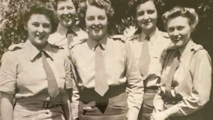 Full-length photograph of five young women in uniform.